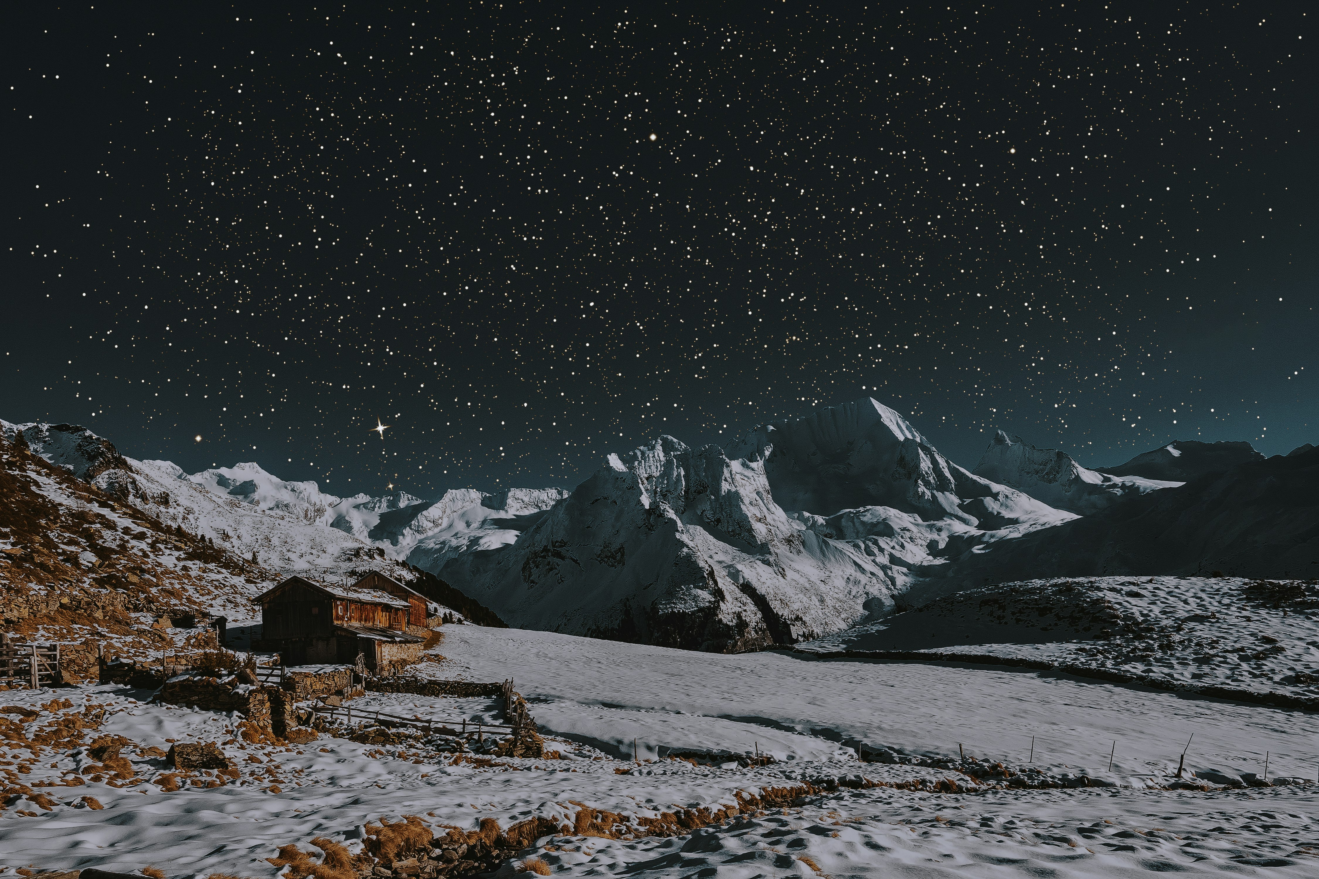 snow covered mountains under dark sky